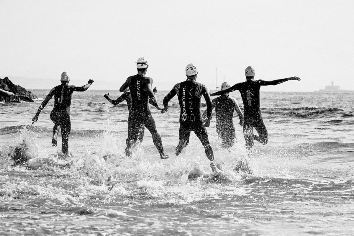 Triathletes swimming, cycling and running during an outdoor triathlon.